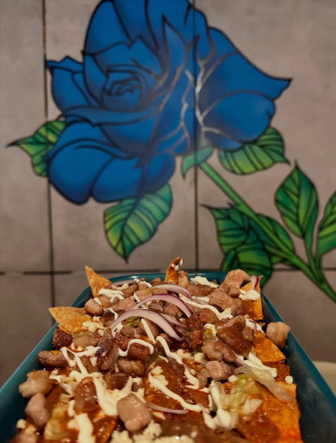 Chilaquiles en Benditos Sueños con mural de rosa azul